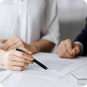 Close up on hands of two women, looking over a contract