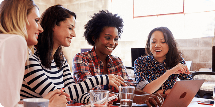Four women looking at a laptop