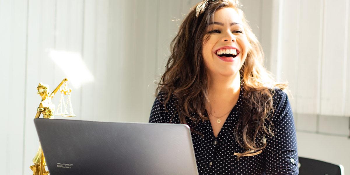 Woman laughing while sitting at a desk